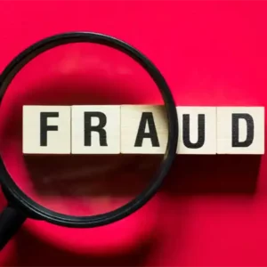 The word "fraud" written in wooden blocks under magnifying glass